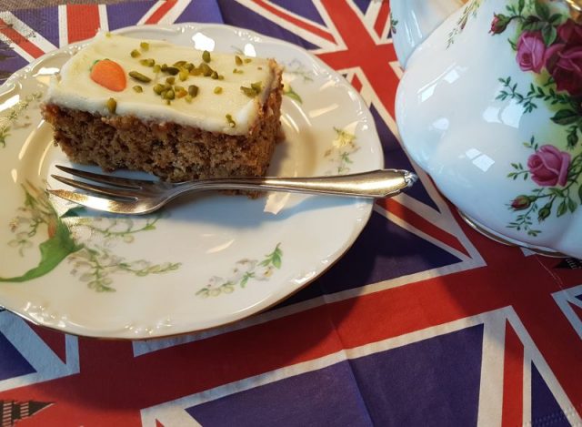 Stück Karottenkuchen auf Teller. Englische Flagge darunter.