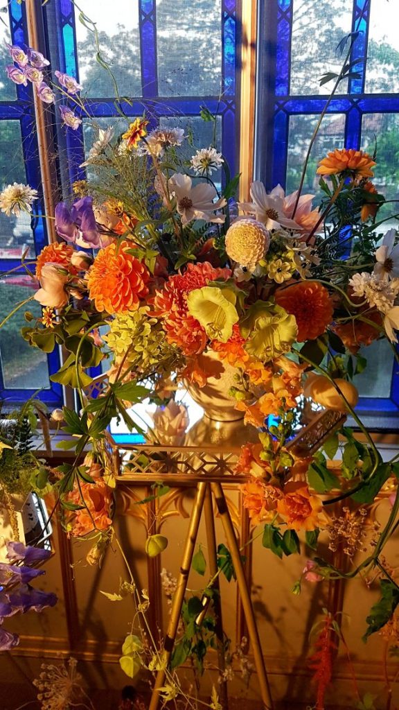 Umweltfreundliche Flowershow im Strawberry Hill House.
Gelb Oranges Blumenbouquet vor blauen Fensterrahmen