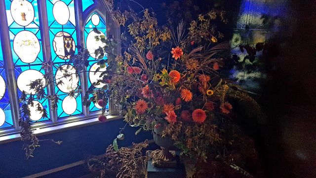 Umweltfreundliche Flowershow im Strawberry Hill House.
Orangenes Bouquet vor blauem Fenster