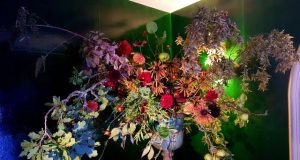 Umweltfreundliche Flowershow im Strawberry Hill House.Blumenkelch mit großem Blumen Bouquet vor grün blauer Wand
