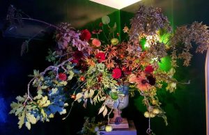 Umweltfreundliche Flowershow im Strawberry Hill House.Blumenkelch mit großem Blumen Bouquet vor grün blauer Wand