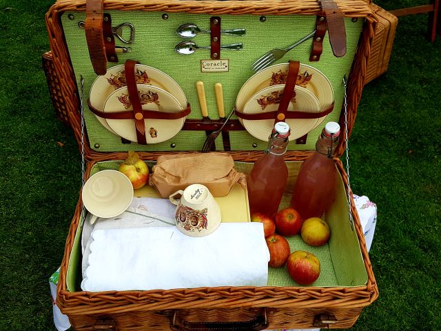 Vintage Picknickkorb mit Äpfeln und Saftflaschen