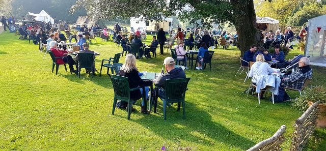 Viele mit Menschen besetzte Tische auf dem Rasen des Highclere Castle zum Afternoon Tea