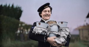Britische Frau in Uniform trägt Essensbehälter für die Royal Navy Kriegsweihnacht