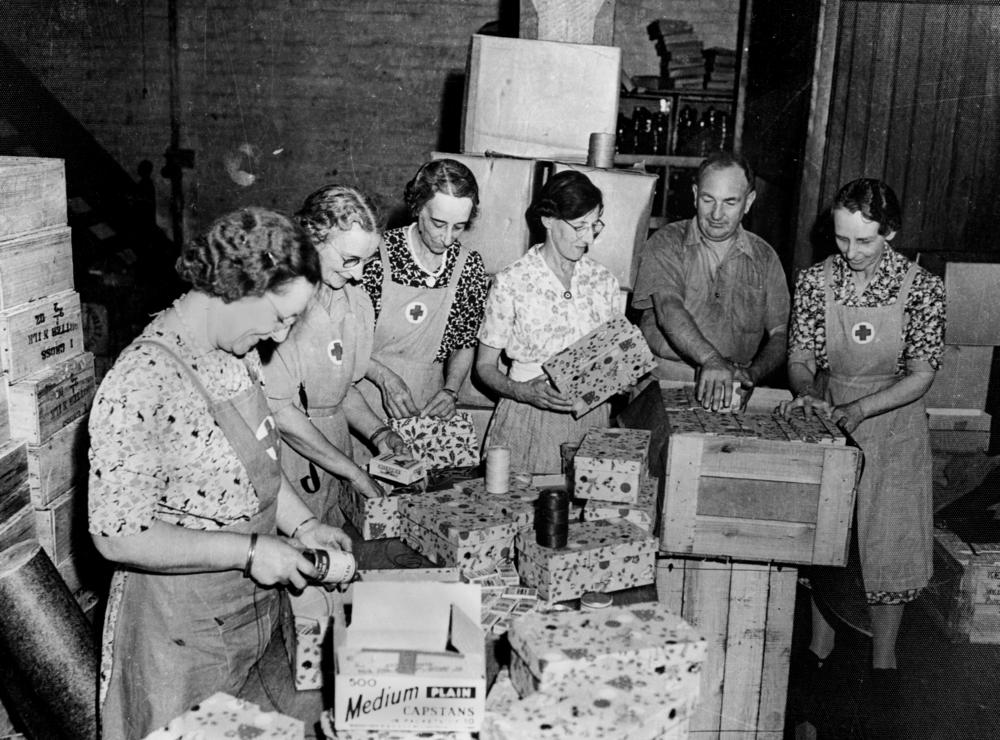 Packerinnen des Roten Kreuzes packen Päckchen für Soldaten während Kriegsweihnacht