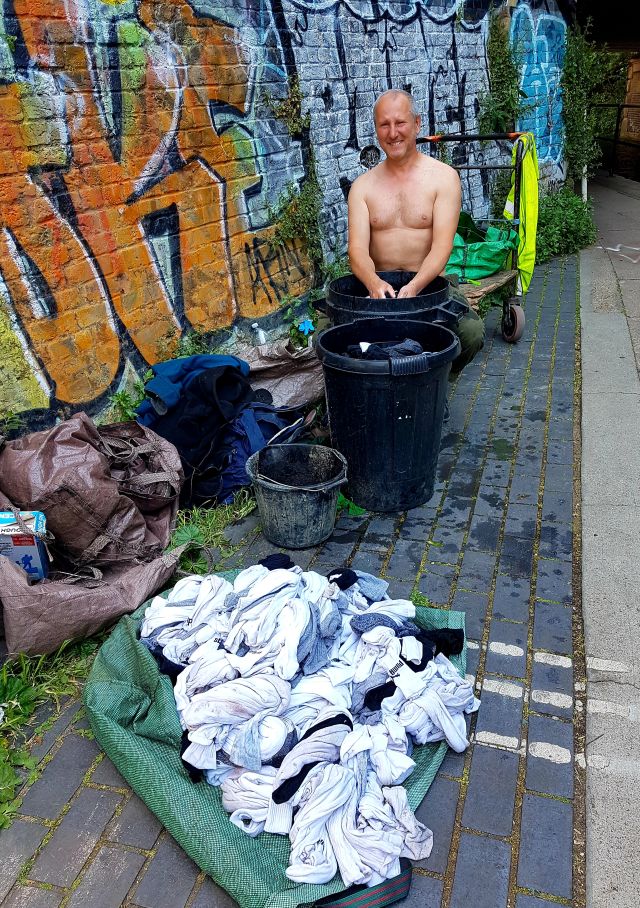 Mann am Waschzuber nasse Wäsche Taschen