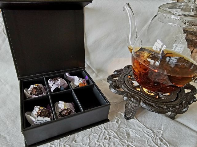 Teekanne aus glas mit Teeblüte Teeaufguss Erblühtee in Magnetbox