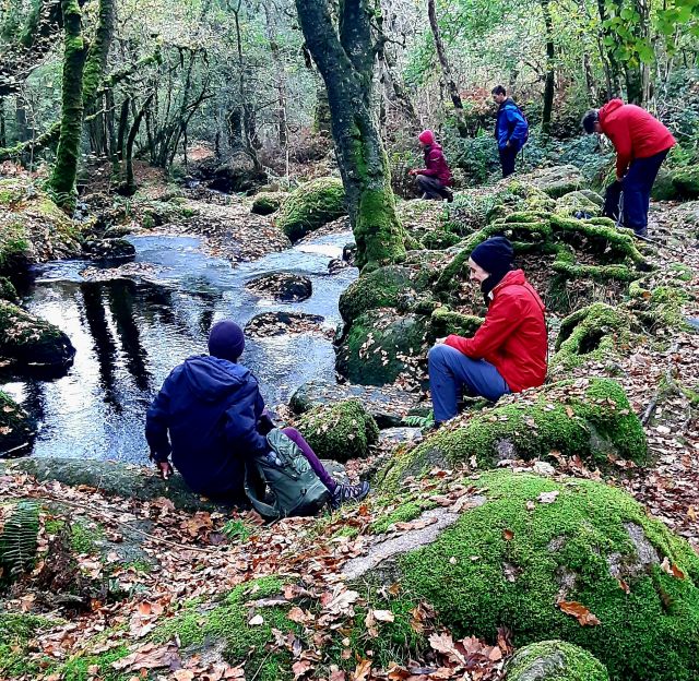 Wanderer sitzen am Bach beim Witch Walk in Dartmoor