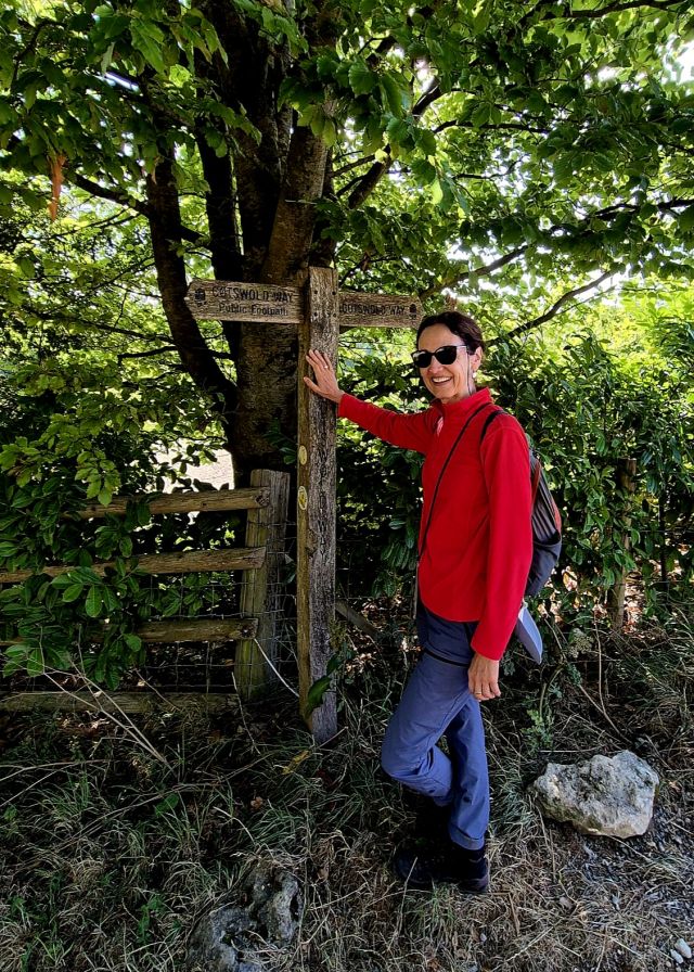 Wegweiser für den Cotswold Way mit Wandererin