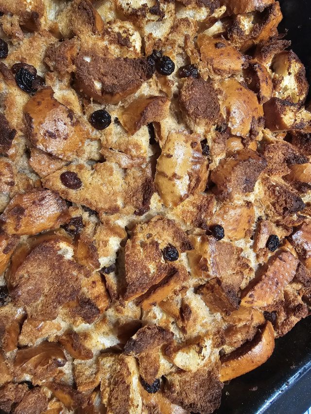 Brotwürfel und Rosinen in Auflaufform getränkt mit Milch für Bread Pudding